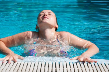 girl swim in summer pool water on vacation.