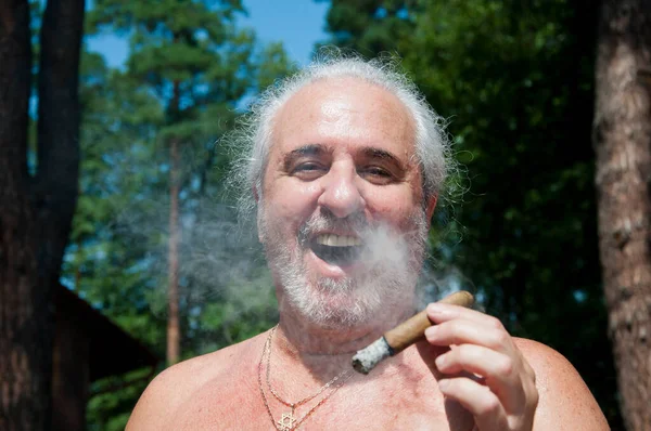 senior man laugh smoking cuban cigar enjoying summer vacation and suntan on retirement.