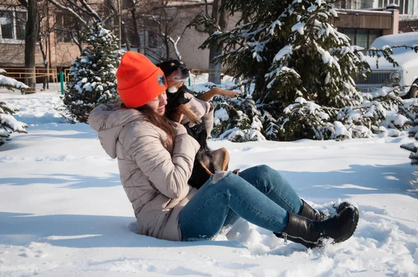 lovely girl play with pet in winter. girl pet lover playing with her dog. girl outside with pet. playful pet outdoor with girl.