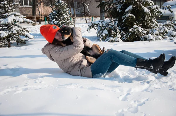 funny girl play with dog in winter. girl pet lover playing with her dog. girl outside with dog. playful dog outdoor with girl.