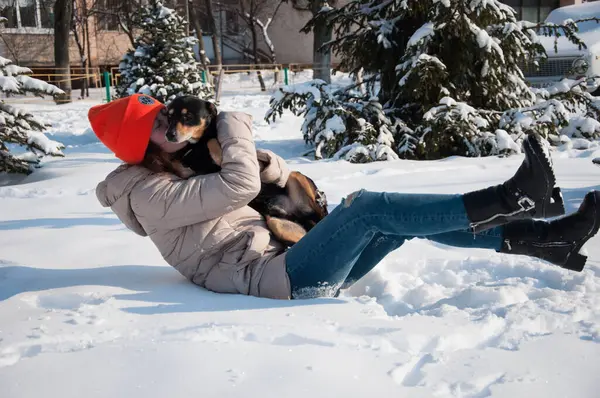 lovely woman play with dog in winter. woman pet lover playing with her dog. woman outside with dog. playful dog outdoor with woman.