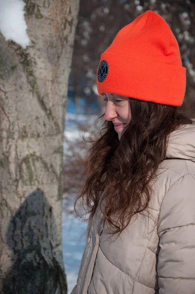 戴着橙色暖帽 戴着雪帽 微笑着的冬季少女 冬雪中戴着一顶暖和帽子的姑娘的冬季风尚 — 图库照片