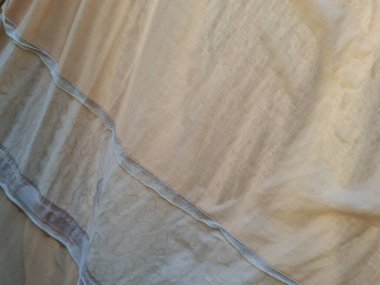 Açık kahverengi kumaş arka plan güneşte katlanmış.