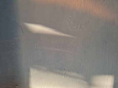 Soyut arkaplan fotoğrafı, güneşte mavi boyalı bir duvar tasvir ediyor, böylece beyaz ve turuncu renkler var.