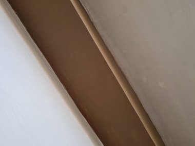 Soyut arkaplan fotoğrafı beyaz boyayla kahverengi boyayı birleştiren bir duvar tasviri