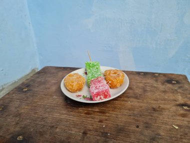 Beyaz tabakta Sate cenil ve Getas denilen tipik Endonezya atıştırmalıkları.