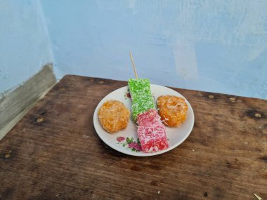 Beyaz tabakta Sate cenil ve Getas denilen tipik Endonezya atıştırmalıkları.