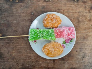 Beyaz tabakta Sate cenil ve Getas denilen tipik Endonezya atıştırmalıkları.