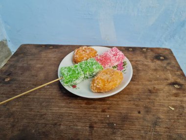 Beyaz tabakta Sate cenil ve Getas denilen tipik Endonezya atıştırmalıkları.