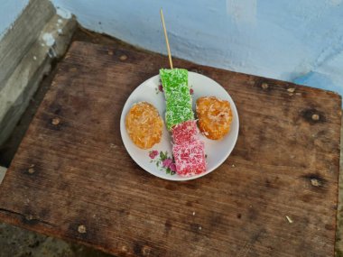 Beyaz tabakta Sate cenil ve Getas denilen tipik Endonezya atıştırmalıkları.