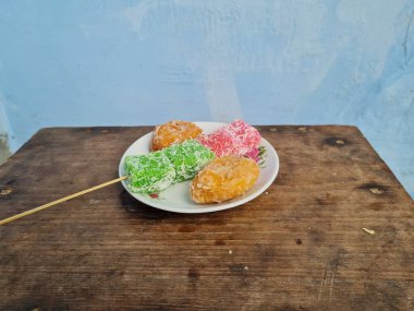 Beyaz tabakta Sate cenil ve Getas denilen tipik Endonezya atıştırmalıkları.