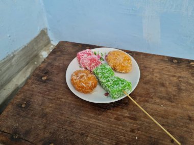 Beyaz tabakta Sate cenil ve Getas denilen tipik Endonezya atıştırmalıkları.