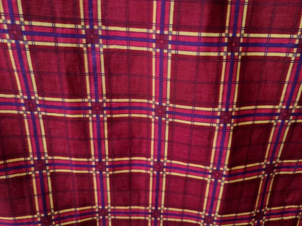 Soyut arkaplan fotoğrafı sarı kareli çizgilerin kombinasyonlu kırmızı bir sarong tasvir ediyor.