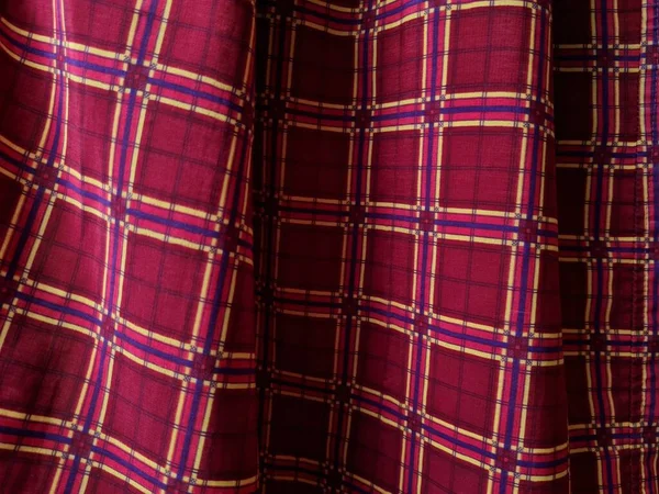 Soyut arkaplan fotoğrafı sarı kareli çizgilerin kombinasyonlu kırmızı bir sarong tasvir ediyor.