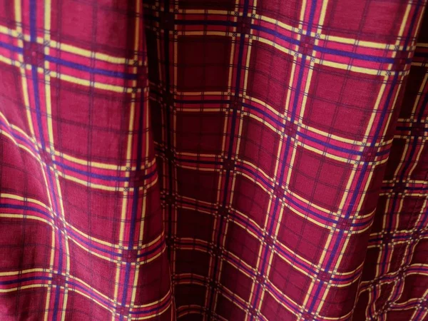 Soyut arkaplan fotoğrafı sarı kareli çizgilerin kombinasyonlu kırmızı bir sarong tasvir ediyor.