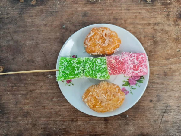 Beyaz tabakta Sate cenil ve Getas denilen tipik Endonezya atıştırmalıkları.