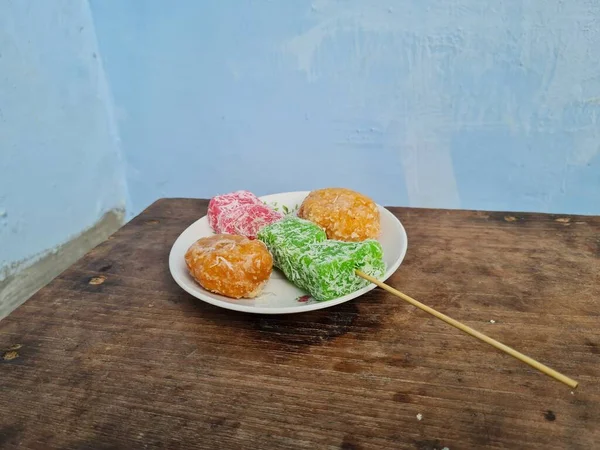 Beyaz tabakta Sate cenil ve Getas denilen tipik Endonezya atıştırmalıkları.