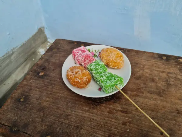 Beyaz tabakta Sate cenil ve Getas denilen tipik Endonezya atıştırmalıkları.