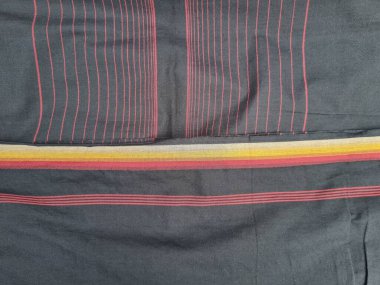 Sargının arka planı sarı ve kırmızı çizgilerin kombinasyonuyla siyahtır.