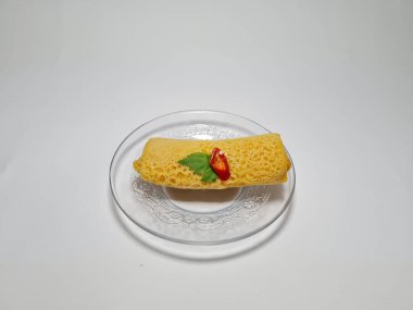 Beyaz arka plandaki bir tabakta Endonezya atıştırmalıklarını yeniden düzenler