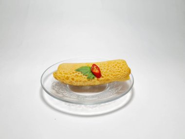 Beyaz arka plandaki bir tabakta Endonezya atıştırmalıklarını yeniden düzenler