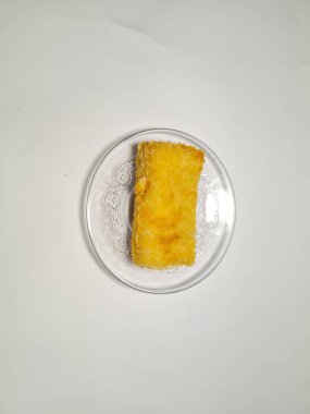 Beyaz arka plandaki bir tabakta Endonezya atıştırmalıklarını yeniden düzenler