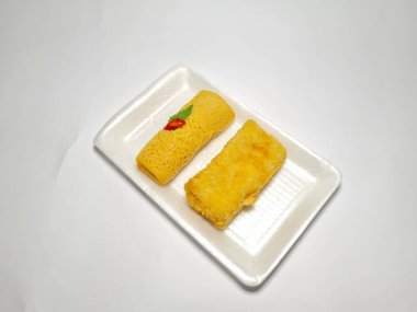 Beyaz arka plandaki bir tabakta Endonezya atıştırmalıklarını yeniden düzenler