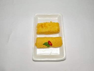 Beyaz arka plandaki bir tabakta Endonezya atıştırmalıklarını yeniden düzenler