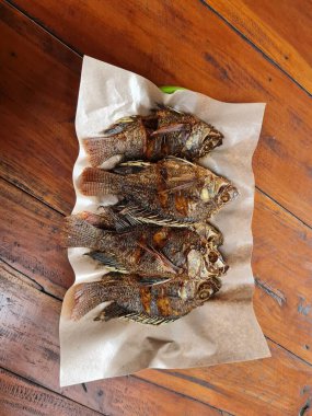 Alüminyum bir kabın içinde dört tatlı ve ekşi tilapia.