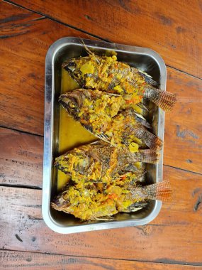 Alüminyum bir kabın içinde dört tatlı ve ekşi tilapia.