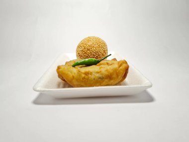 Beyaz bir arka planda tuzlu martabak ve onde-onde adlı sokak yemekleri