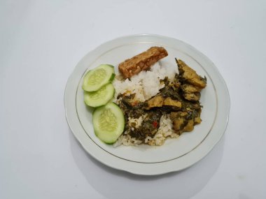 Yanında soya peyniri, dilimlenmiş, beyaz bir tabakta salatalık dilimlenmiş beyaz pirinç.