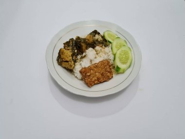 Yanında soya peyniri, dilimlenmiş, beyaz bir tabakta salatalık dilimlenmiş beyaz pirinç.