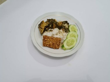 Yanında soya peyniri, dilimlenmiş, beyaz bir tabakta salatalık dilimlenmiş beyaz pirinç.