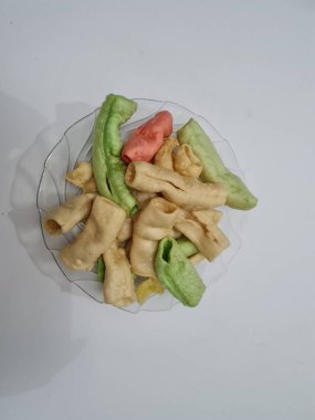 Beyaz arka planda bir tabakta renkli Impala krakerleri