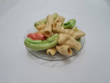 Beyaz arka planda bir tabakta renkli Impala krakerleri