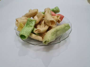 Beyaz arka planda bir tabakta renkli Impala krakerleri