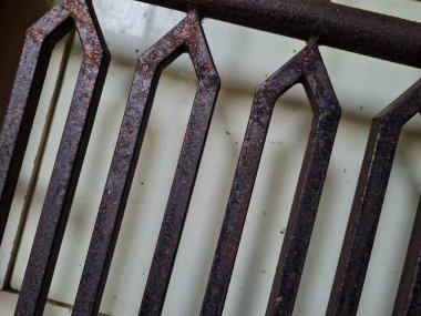 Önündeki beyaz ahşap kapının arka planı güvenlik olarak kahverengi bir demir çit.