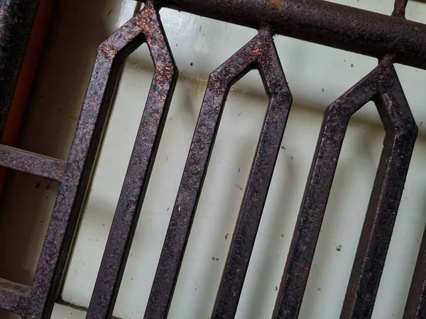 Önündeki beyaz ahşap kapının arka planı güvenlik olarak kahverengi bir demir çit.