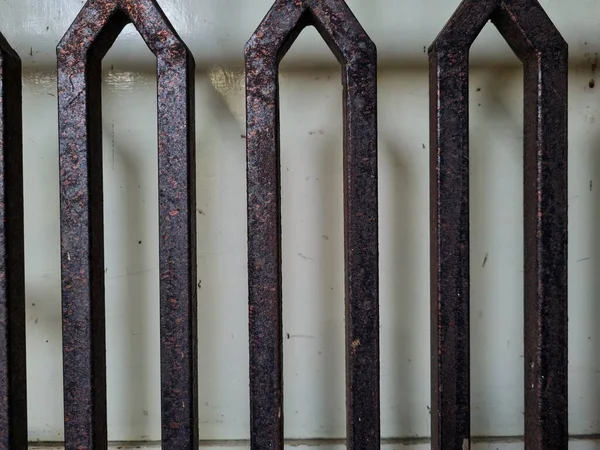 Önündeki beyaz ahşap kapının arka planı güvenlik olarak kahverengi bir demir çit.