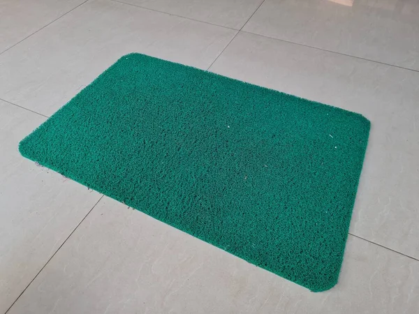 铺在白瓷地板上的绿色橡胶做的漂亮垫子 — 图库照片