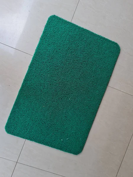 铺在白瓷地板上的绿色橡胶做的漂亮垫子 — 图库照片