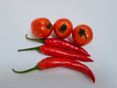 Yeşil saplı büyük kırmızı biberler ve ekstra baharat için beyaz arka planda büyük kırmızı biberler.