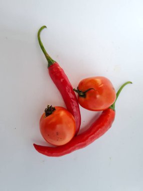 Yeşil saplı büyük kırmızı biberler ve ekstra baharat için beyaz arka planda büyük kırmızı biberler.