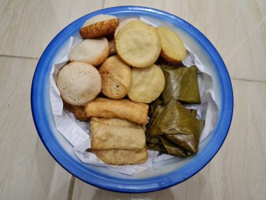 Endonezya 'dan gelen abur cuburlar; çamur kekleri, apem kekleri, tavuk dolgulu pirzolalar ve mavi beyaz bir kapta mendut kekleri.