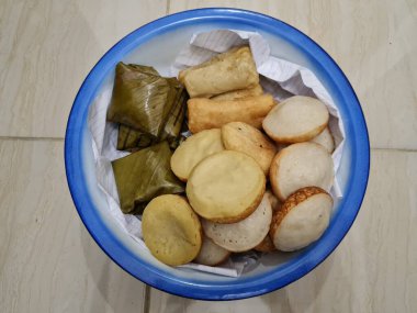 Endonezya 'dan gelen abur cuburlar; çamur kekleri, apem kekleri, tavuk dolgulu pirzolalar ve mavi beyaz bir kapta mendut kekleri.