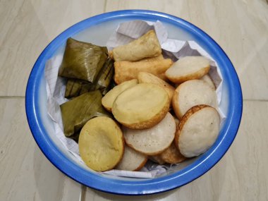 Endonezya 'dan gelen abur cuburlar; çamur kekleri, apem kekleri, tavuk dolgulu pirzolalar ve mavi beyaz bir kapta mendut kekleri.