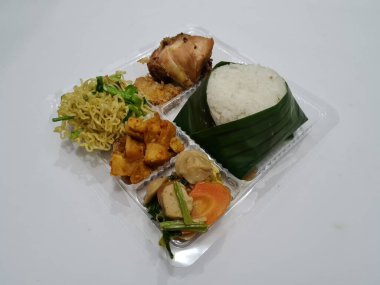 Beyaz pirinç, kızarmış erişte, kızarmış acı biber sosu, kızarmış tavuk, kırmızı biber sosu ve capcay sebzesi içeren Endonezya 'dan bir yemek.