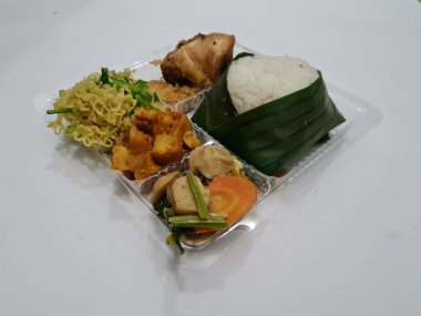 Beyaz pirinç, kızarmış erişte, kızarmış acı biber sosu, kızarmış tavuk, kırmızı biber sosu ve capcay sebzesi içeren Endonezya 'dan bir yemek.