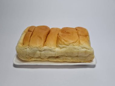 Çikolata aromalı ekmek beyaz bir kabın içinde elle parçalanabilir.